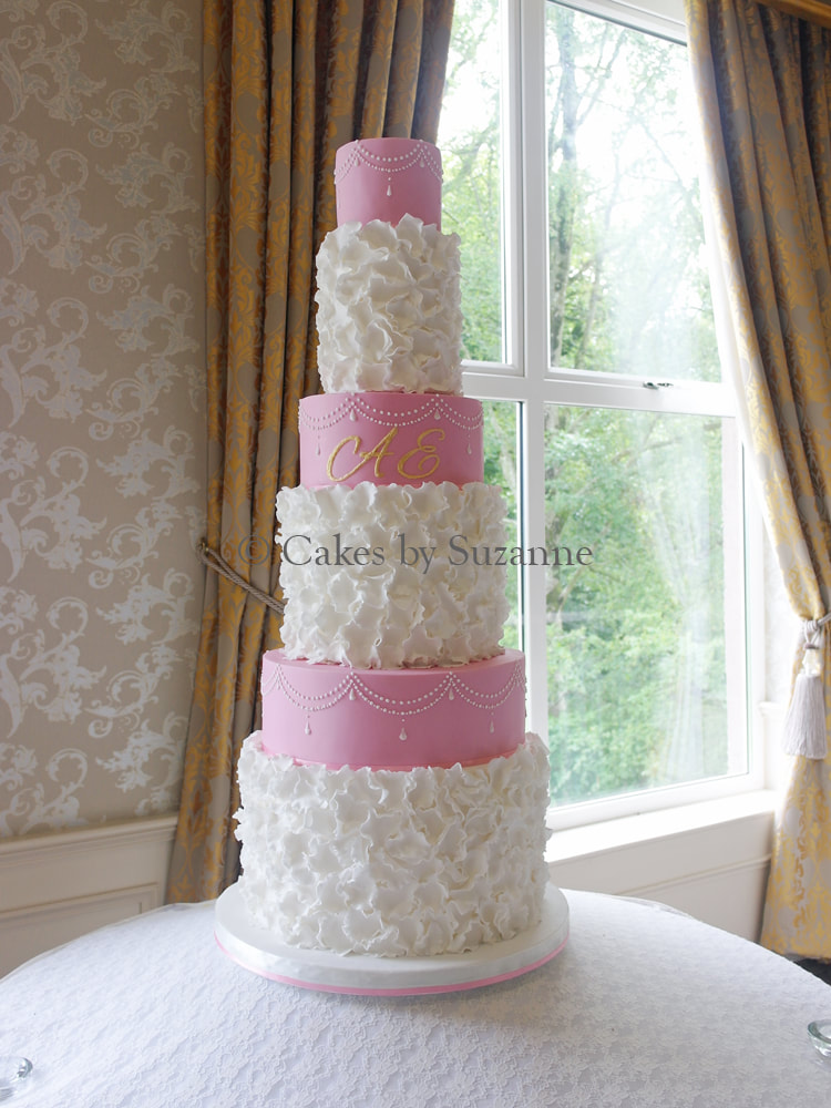 six tier round pink and white ruffles wedding cake