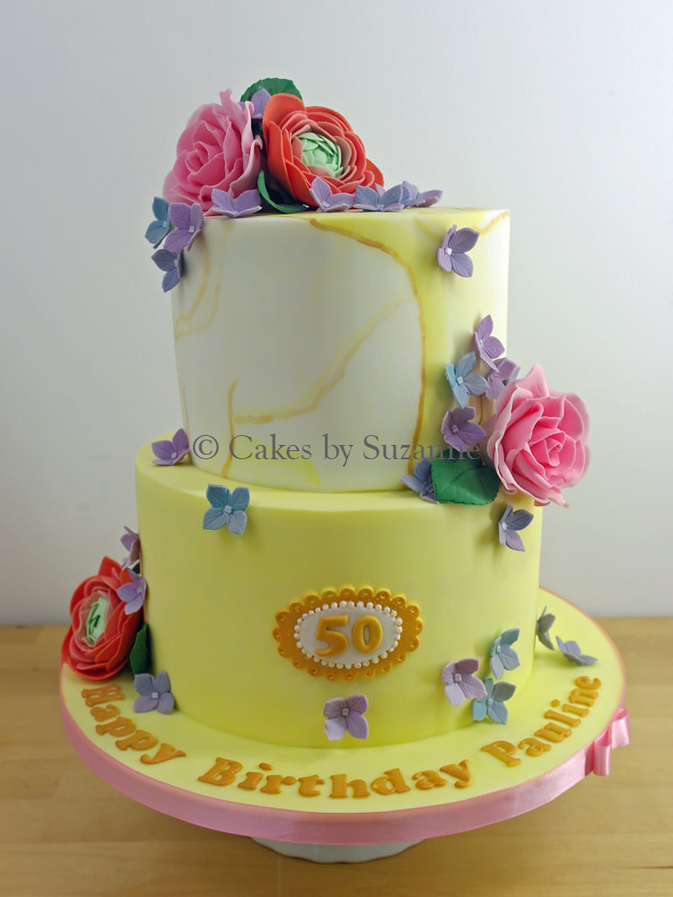 two tier 50th birthday cake with bright coloured flowers