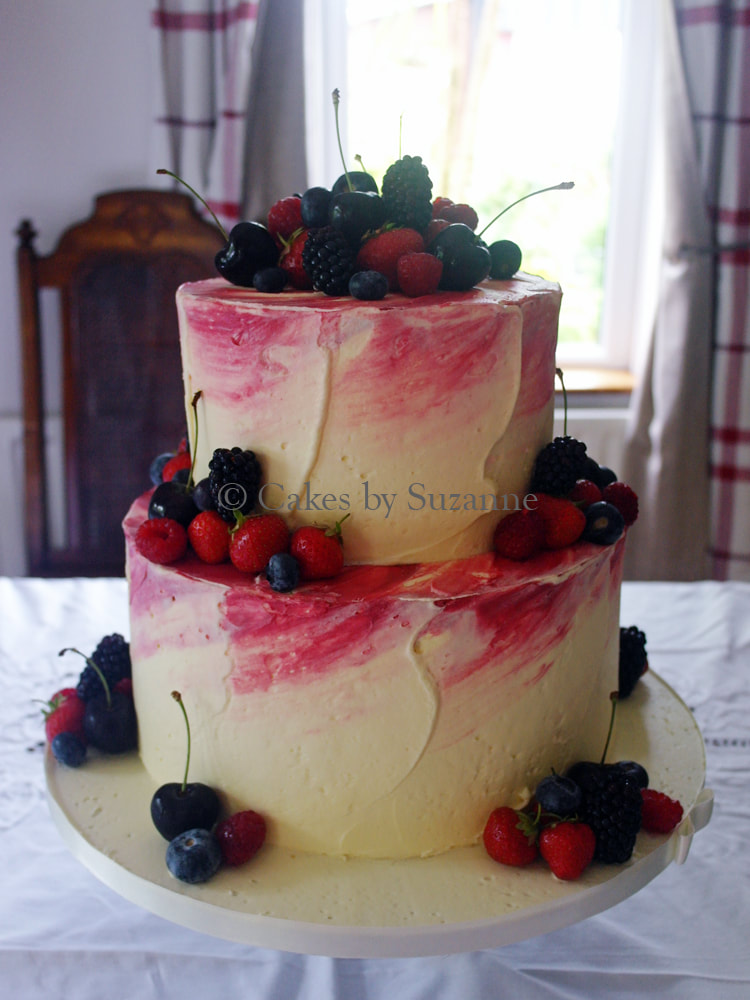 last minute two tier round wedding cake with pink watercolour buttercream effect with added fresh fruit decoration.