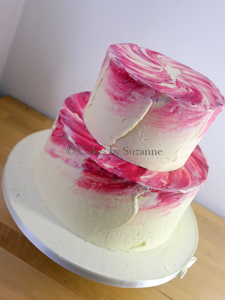 two tier round wedding cake with pink watercolour buttercream