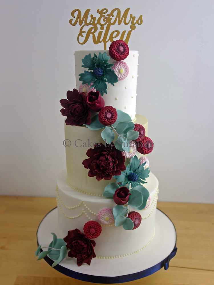 three tier round stacked wedding cake with autumnal sugar flowers and personalised topper
