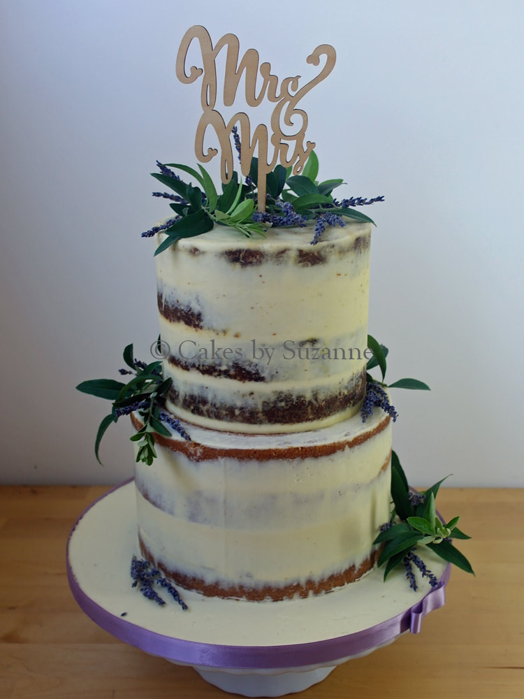 two tier round rustic semi naked buttercream wedding cake with lavender and olive leaves