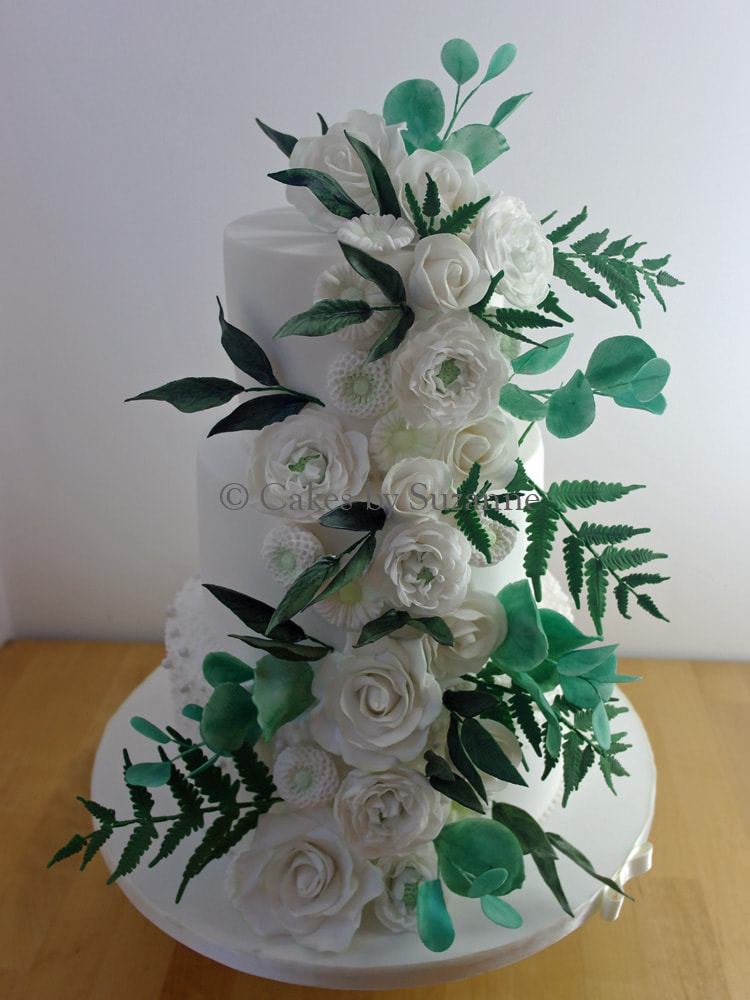 three tier round wedding cake with sugar roses and leaves