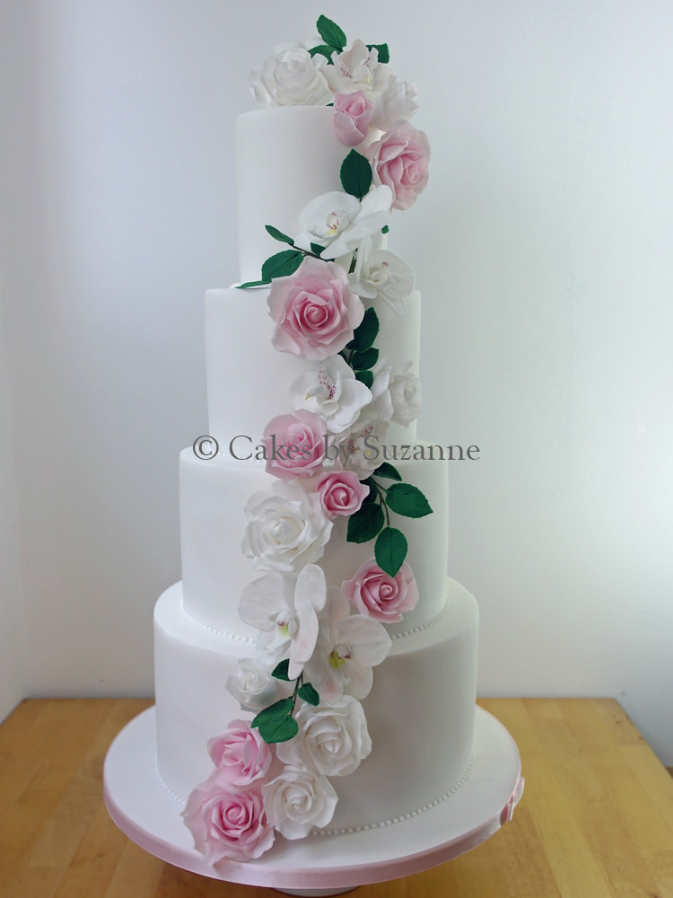 four tier round wedding cake with pink and white rose and orchid cascade