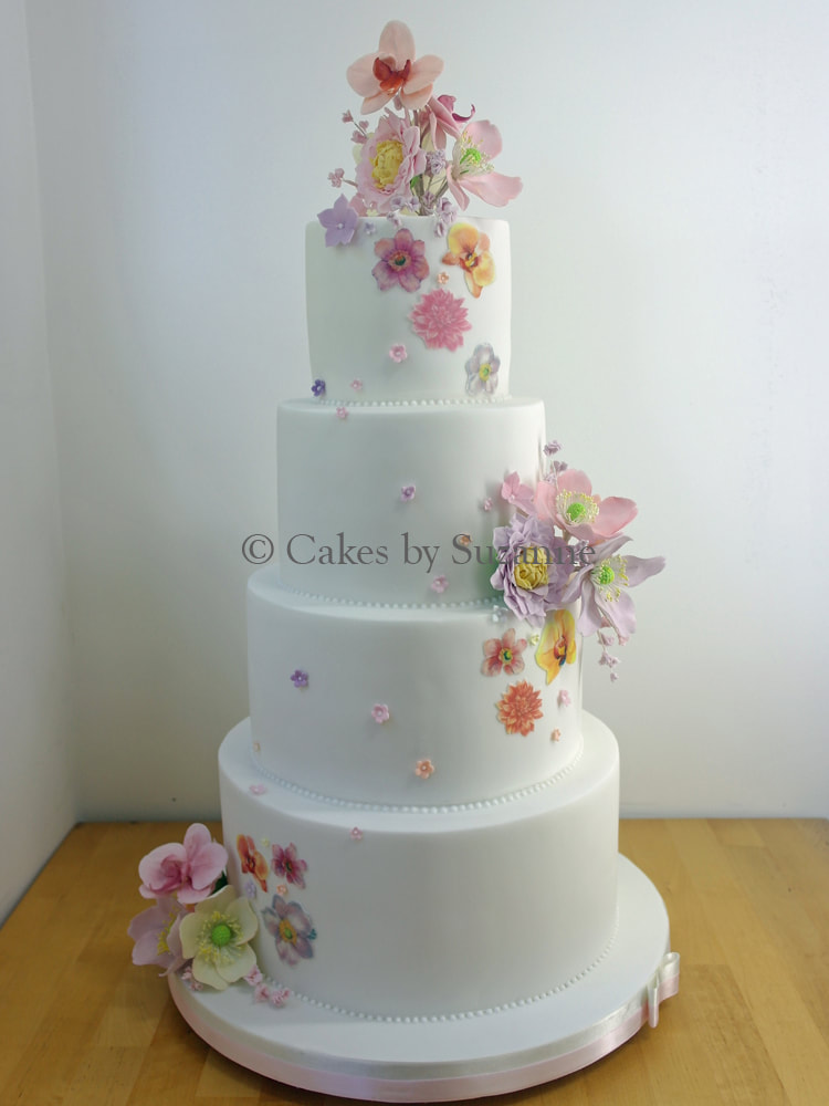four tier round wedding cake with orchids and dahlias