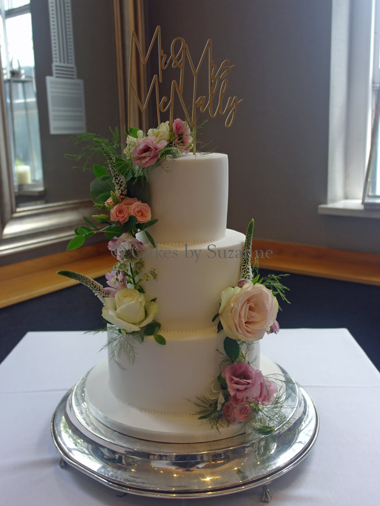 three tier round wedding cake with fresh flowers