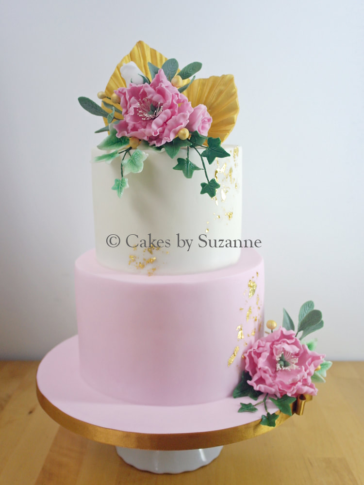 two tier round wedding cake with pink peonies, sage, ivy, palm spears