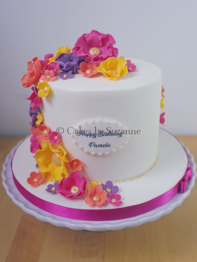 small single tier birthday cake with bright sugar floral cascade
