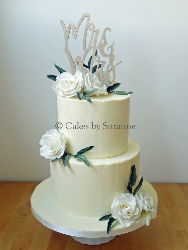 two tier round stacked buttercream wedding cake with sugar roses