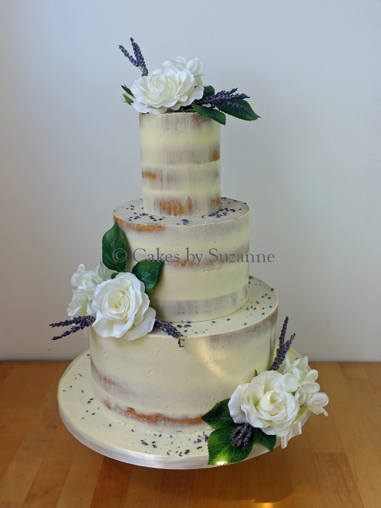 three tier round stacked semi naked buttercream wedding cake with silk roses and dried lavender