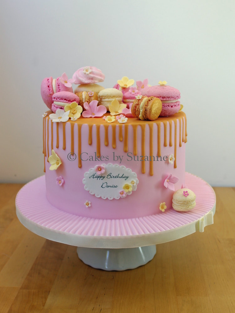 single tier drip effect cake with macarons and sugar blossoms