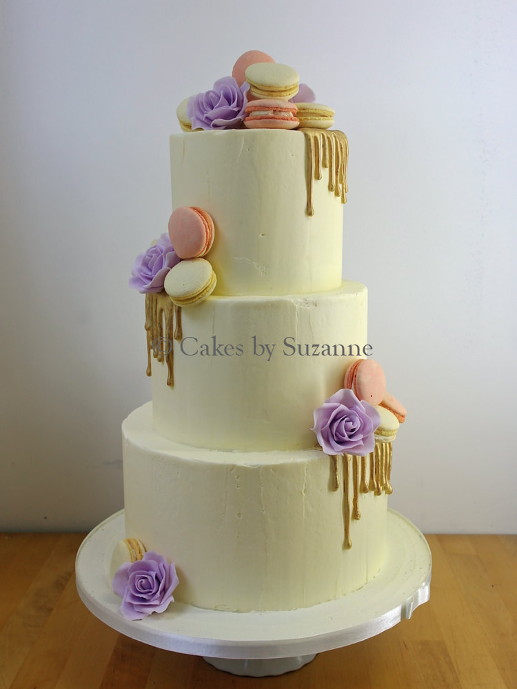 three tier round buttercream wedding cake with gold drip and macarons