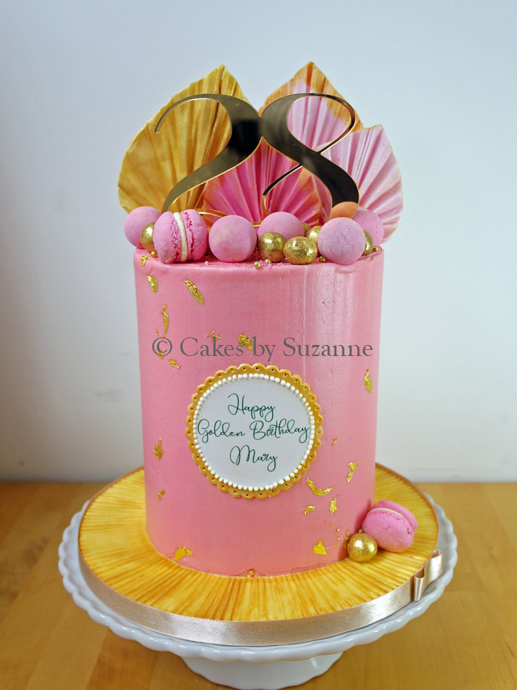 double height tall buttercream cake with sugar palm spears, macarons and chocolate truffles