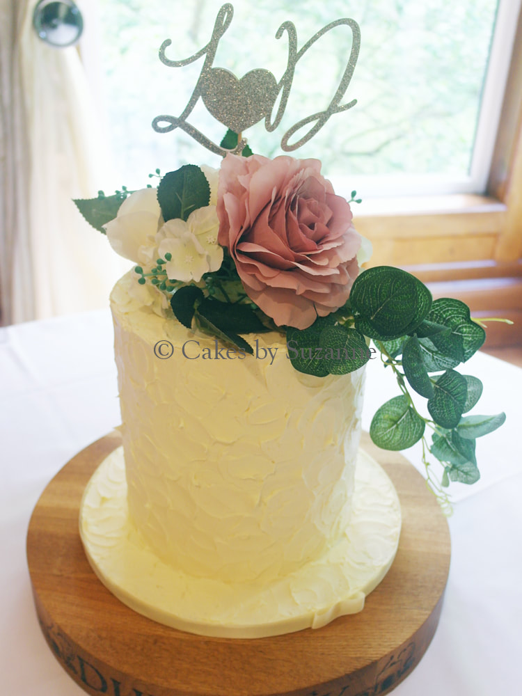 double height wedding cake with silk flowers and personalised topper