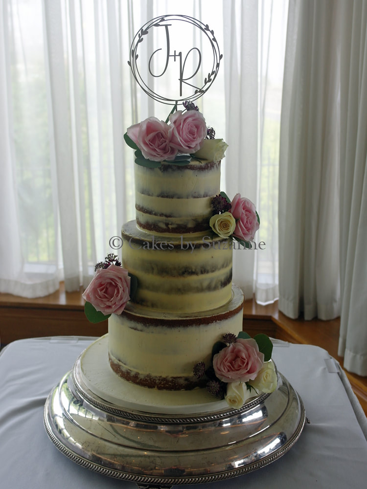 three tier round semi naked buttercream wedding cake with fresh flowers