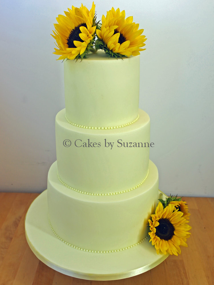 three tier round stacked lemon wedding cake with fresh sunflowers