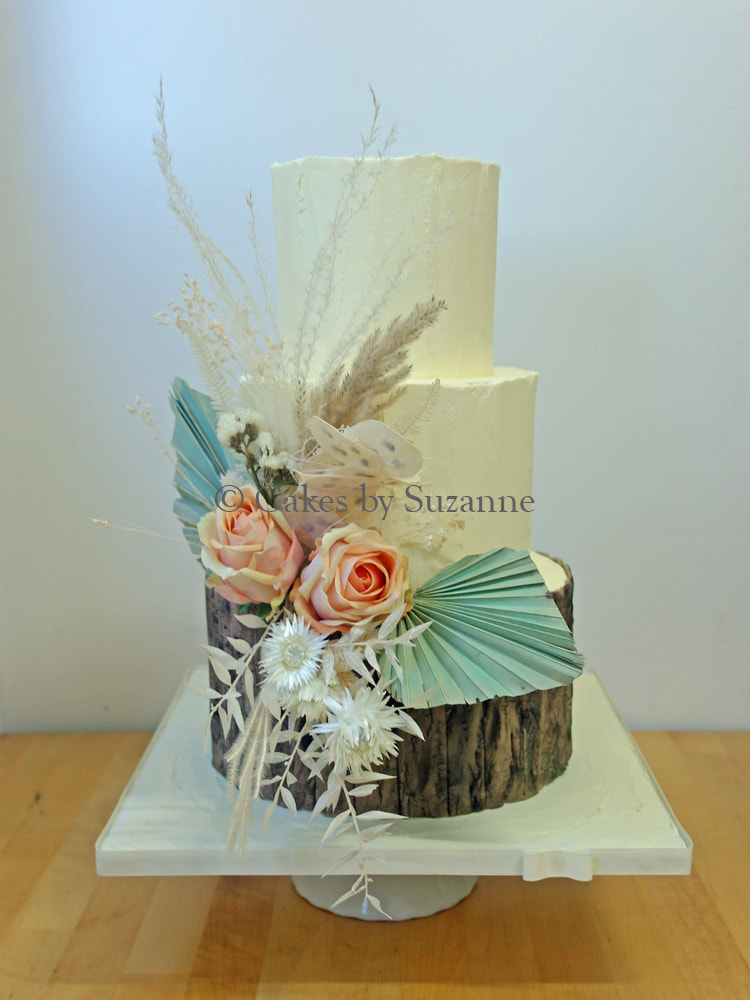three tier round buttercream wedding cake with dried flowers