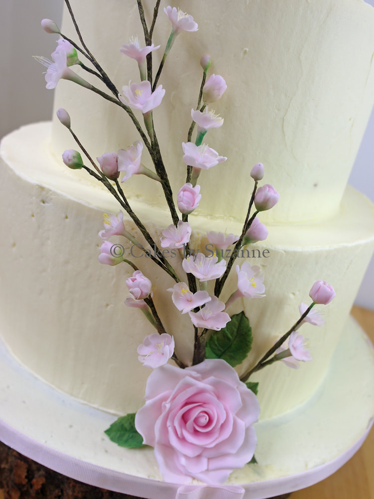 detail of sugar rose and cherry blossom on wedding cake