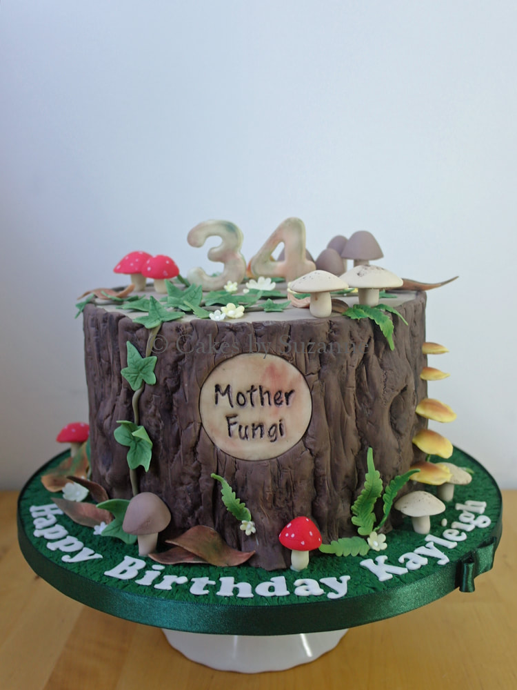 tree stump effect birthday cake with sugar flowers, foliage and fungi
