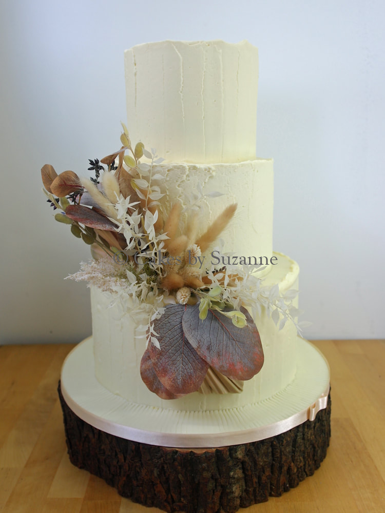 three tier round buttercream wedding cake with dried flowers