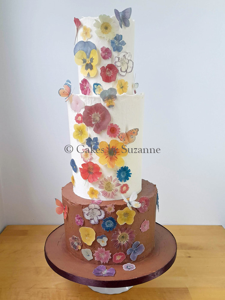 three tier round buttercream cake with wafer paper pressed flowers